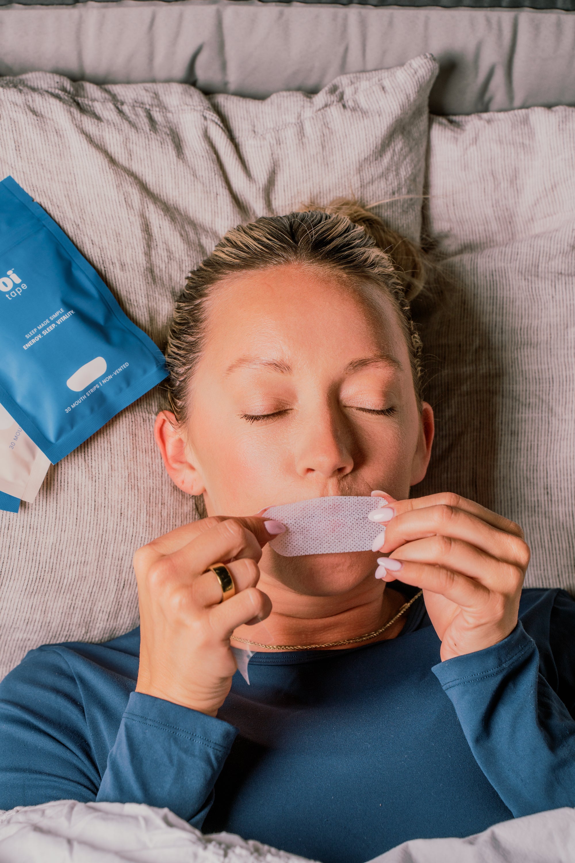 oi tape non-vented mouth tape on women while she is sleeping to help with snoring, dry mouth, and other sleep issues.